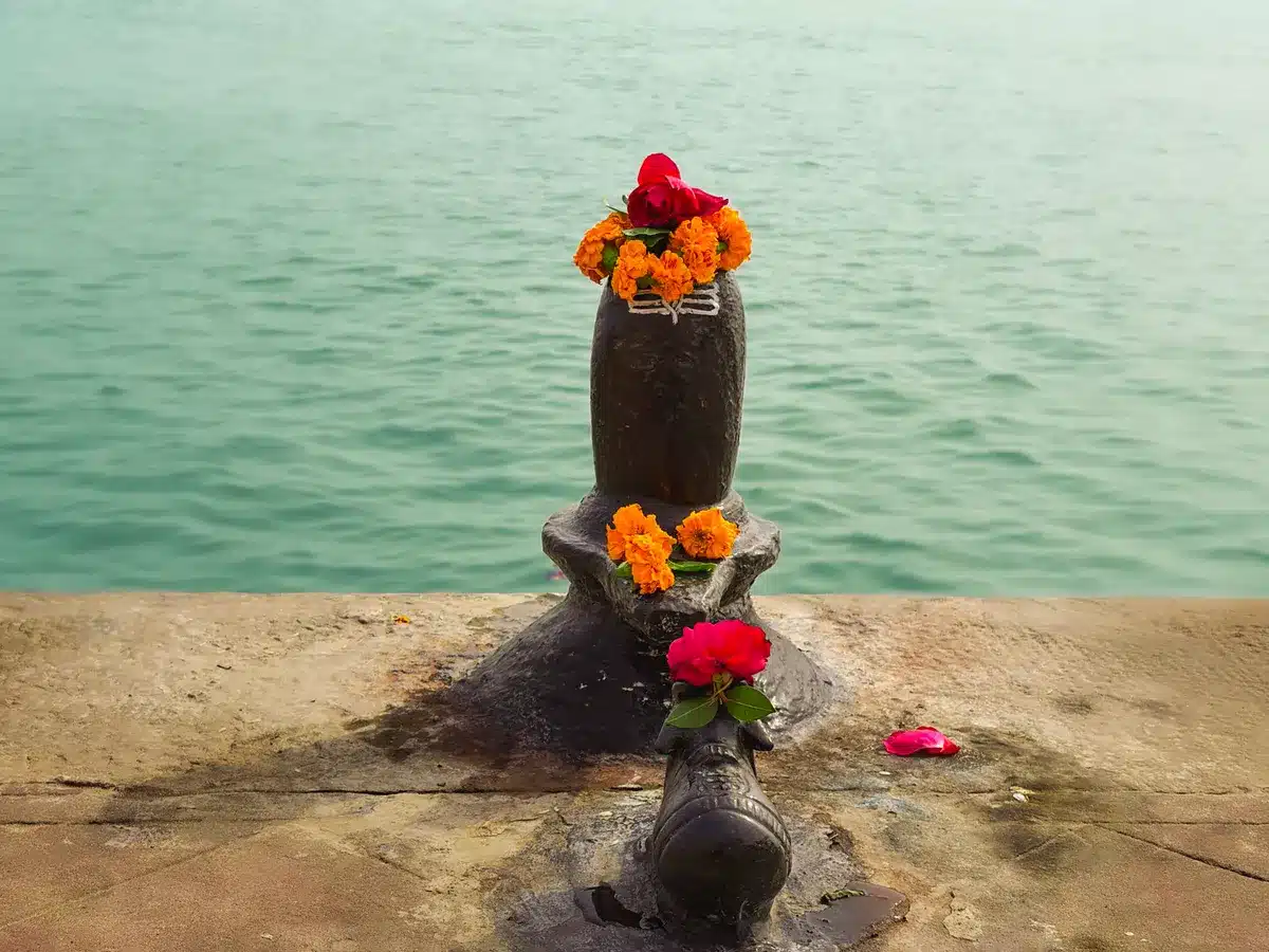 सोमवार व्रत कथा: शिव जी के व्रत की पूरी कथा, पूजा विधि और नियम नदी किनारे घाट पर फूलों से सजा शिवलिंग