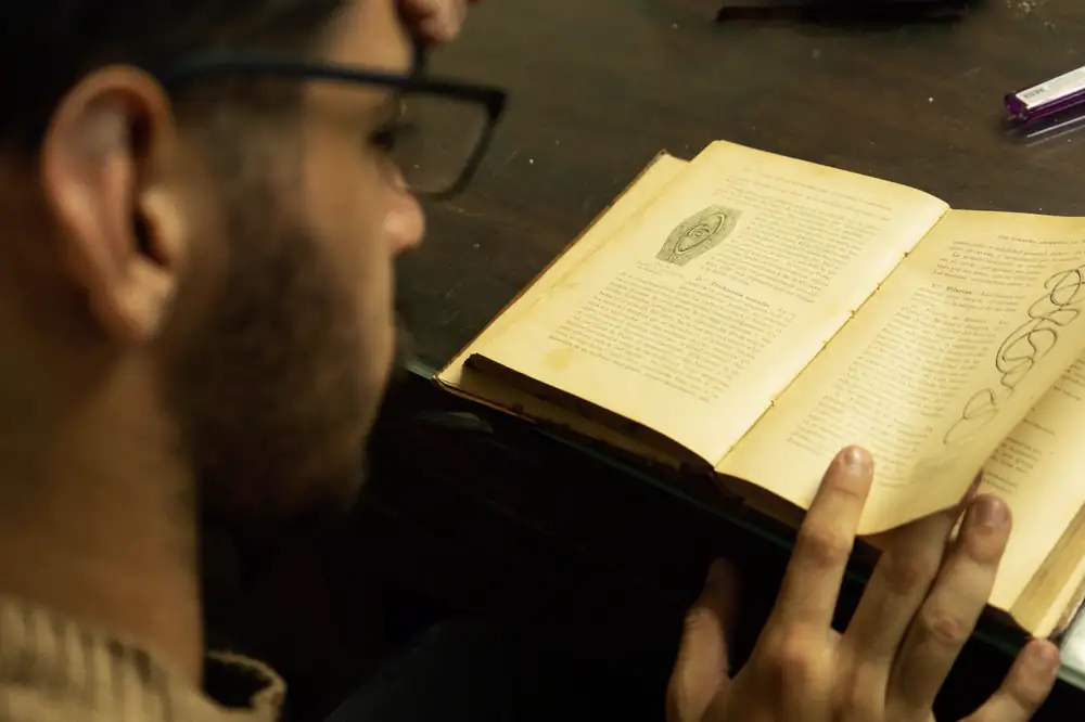 बड़े भाई साहब कहानी का सारांश: कक्षा 10, पात्रों का चरित्र चित्रण, उद्देश्य और प्रश्न उत्तर (Bade Bhai Sahab Summary) बड़े भाई साहब: पुरानी किताब को ध्यान से पढ़ता हुआ एक व्यक्ति