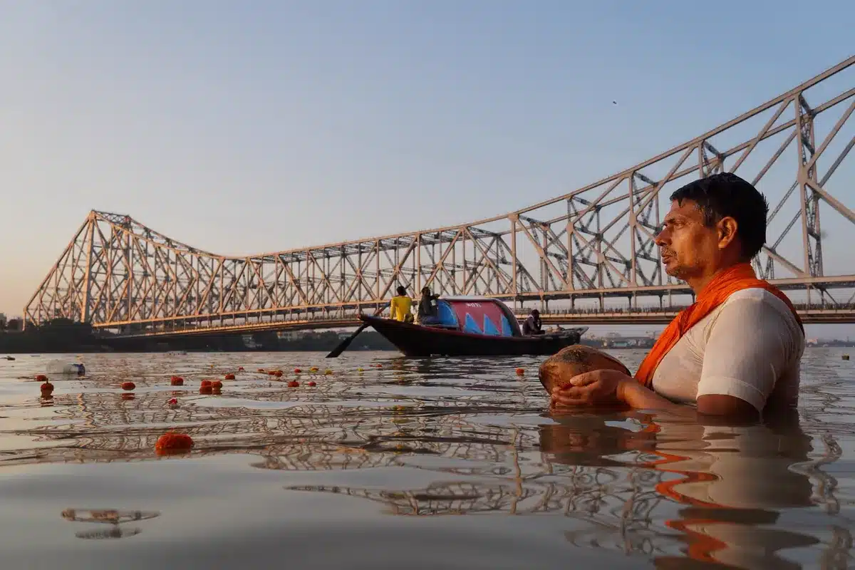 पितृ पक्ष और तर्पण विधि: रोज़ तर्पण कैसे करें, पूरी शास्त्रीय विधि, मंत्र, श्राद्ध के नियम और 2027 की तिथियाँ नदी में खड़े होकर लोटे से जल अर्पित करते व्यक्ति