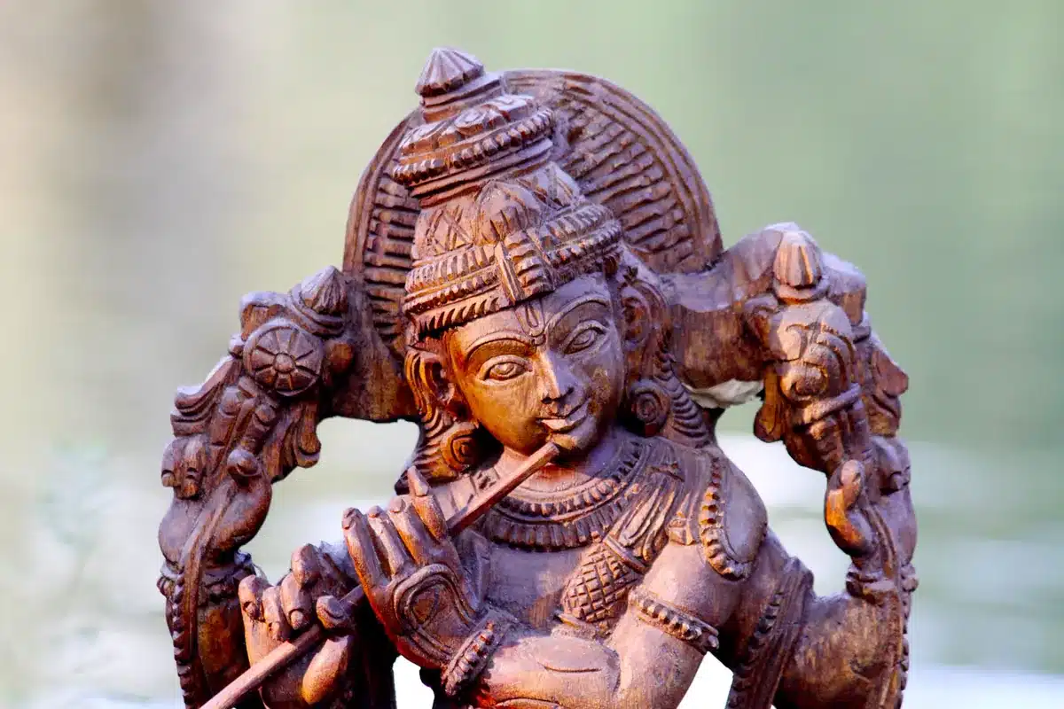 सूरदास के पद अर्थ सहित: कक्षा 10 के 4 पद (भावार्थ, प्रश्न उत्तर) और बाल लीला के प्रसिद्ध पद लकड़ी पर उकेरी बाँसुरी बजाते कृष्ण की मूर्ति